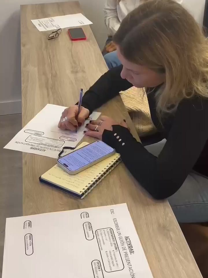 Una asesora escribe su guion de presentación durante un taller